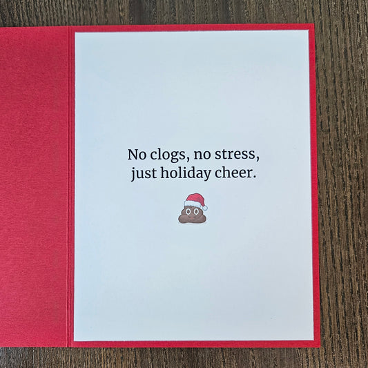 Inside of red Christmas card reading No clogs, no stress, just holiday cheer, with a small poop emoji in a Santa hat.