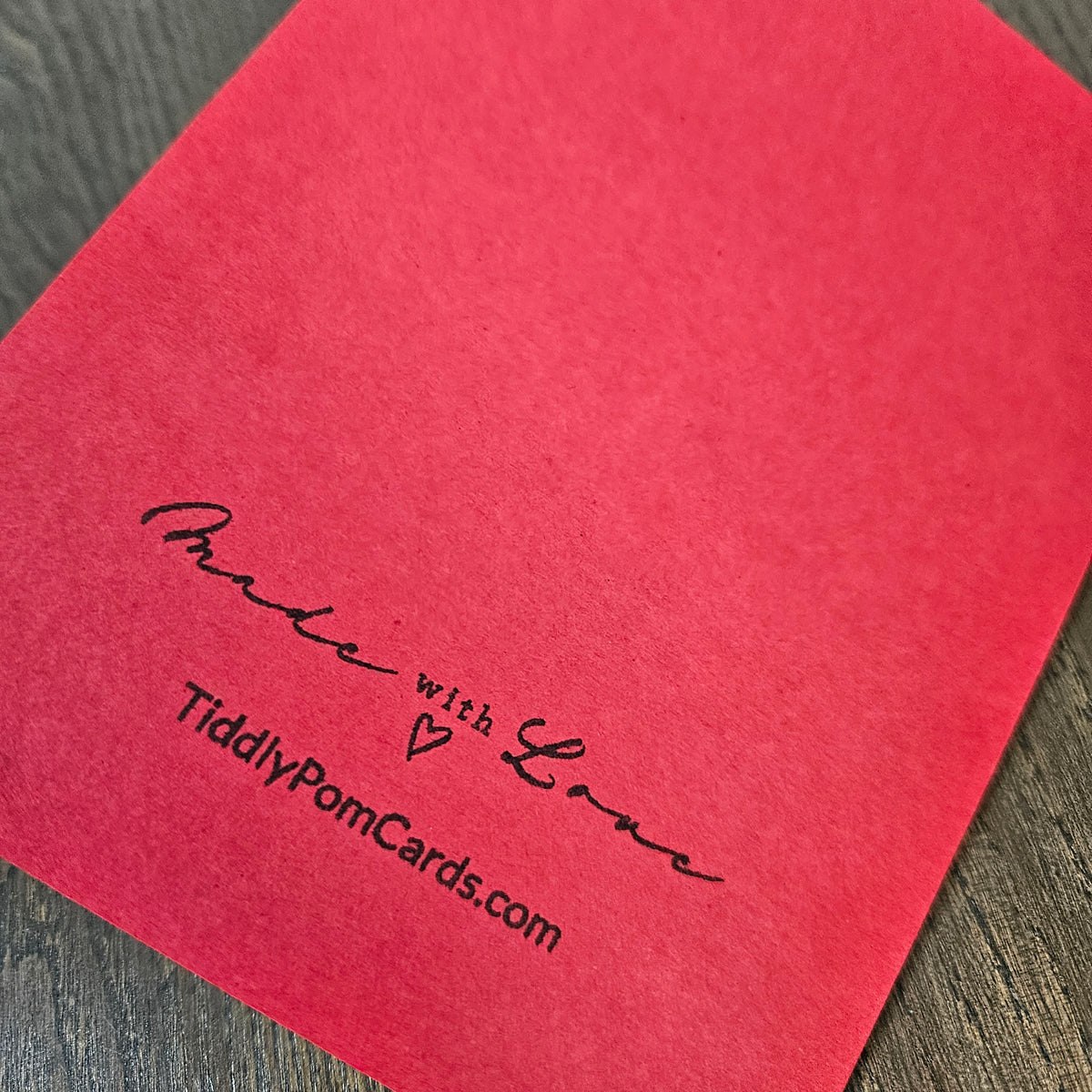Red back of the handmade Christmas card stamped Made with Love and TiddlyPomCards.com.