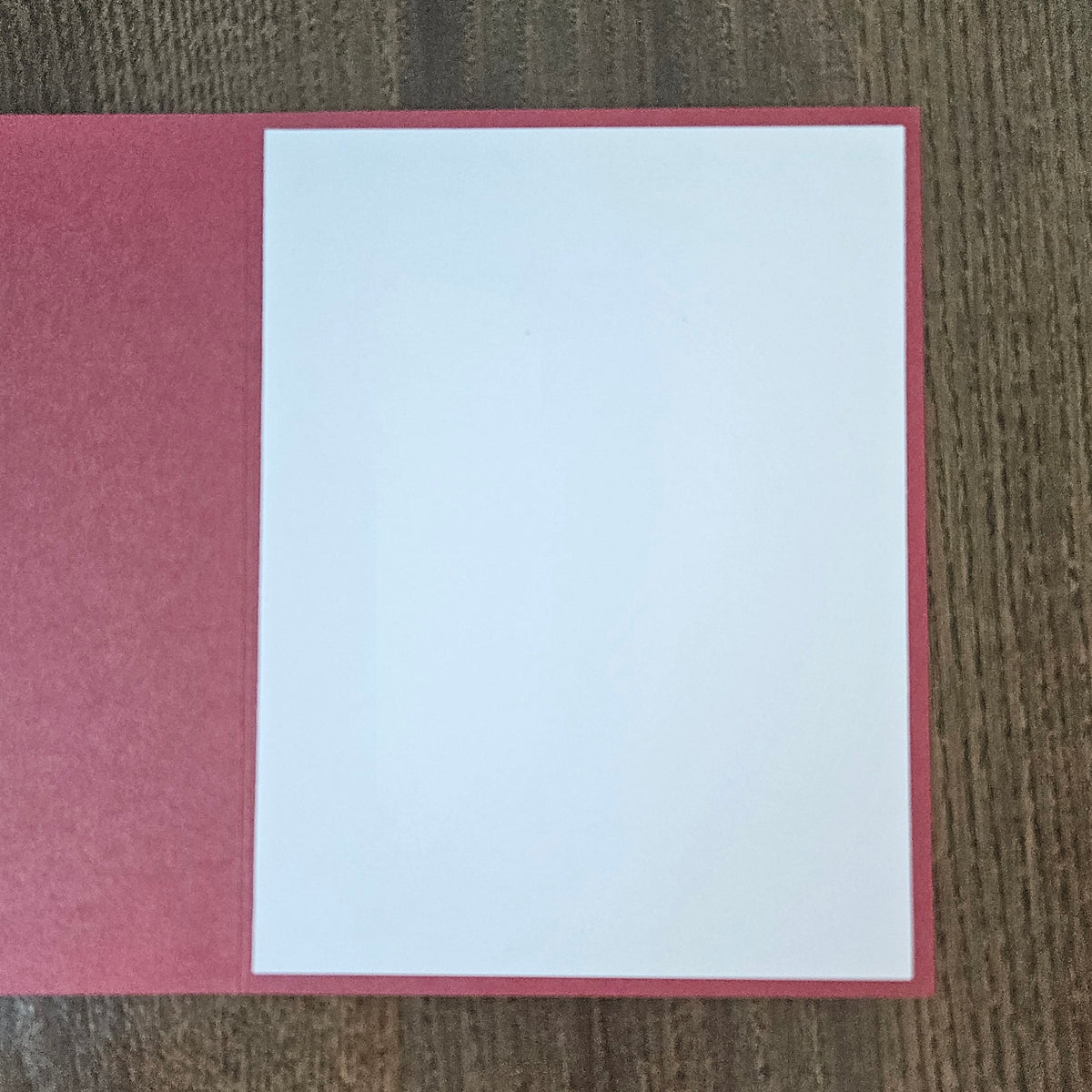 Open muted red Christmas card showing the blank white inside panel for a personal holiday message.