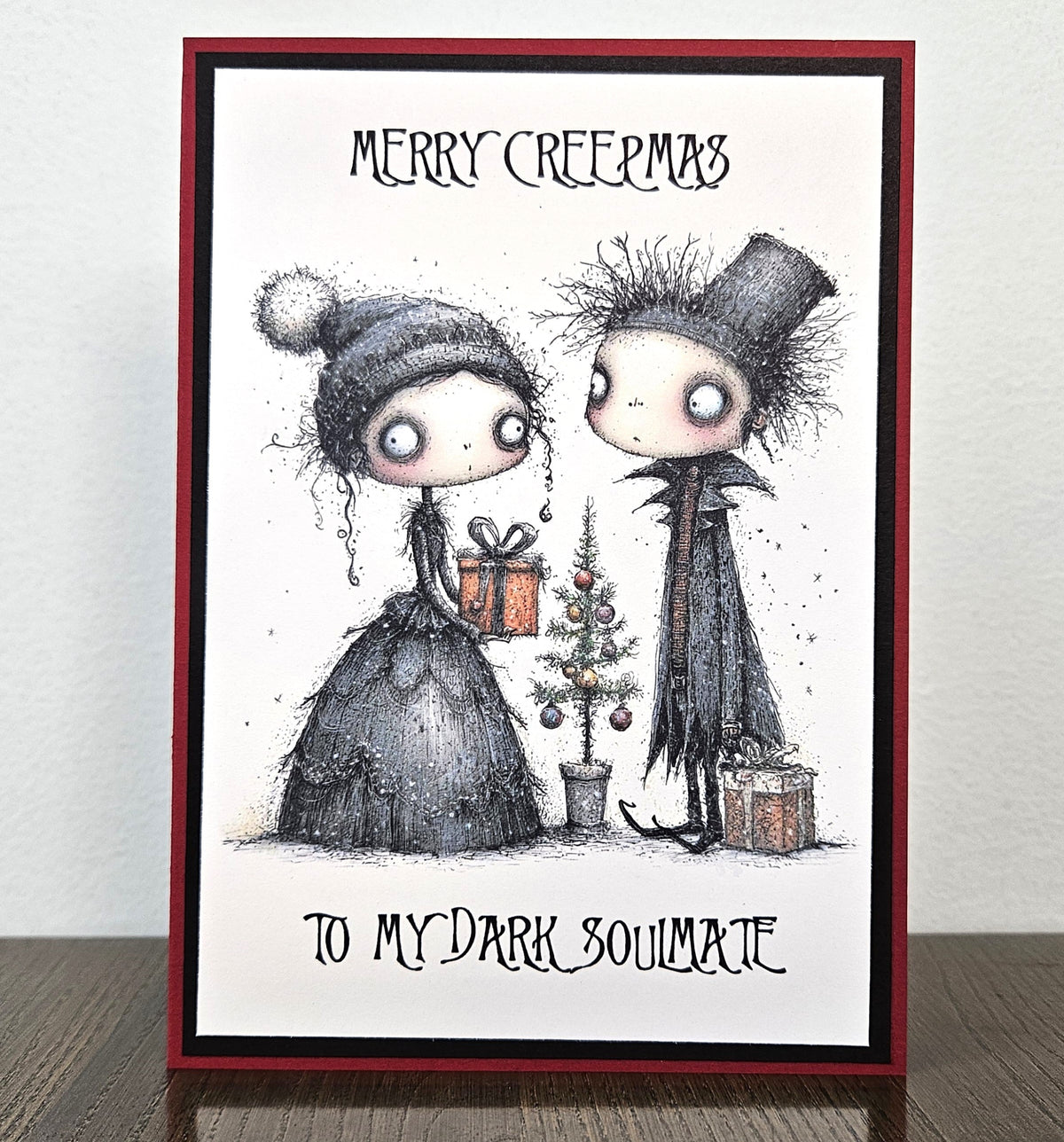 Handmade Merry Creepmas card for a dark soulmate with a gothic couple exchanging gifts beside a Christmas tree