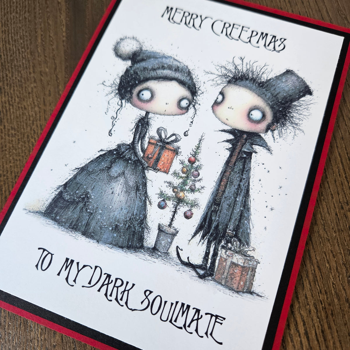 Angled detail of gothic couple, Christmas gifts and Merry Creepmas dark soulmate wording