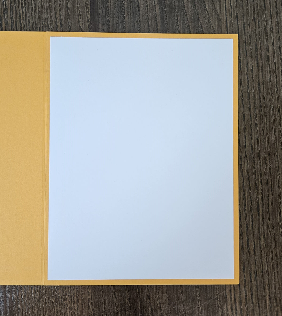 Open yellow greeting card showing a blank white inside panel for a handwritten message.
