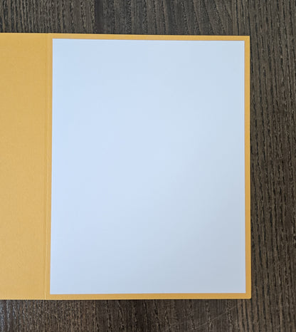 Open yellow greeting card showing a blank white inside panel for a handwritten message.