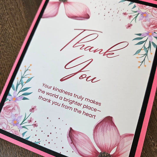 Angled close-up of pink and purple flowers surrounding Thank You and Your kindness truly makes the world a brighter place, thank you from the heart.