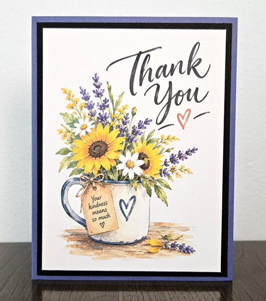 Handmade sunflower and lavender thank you card with a floral mug, black mat and purple base.
