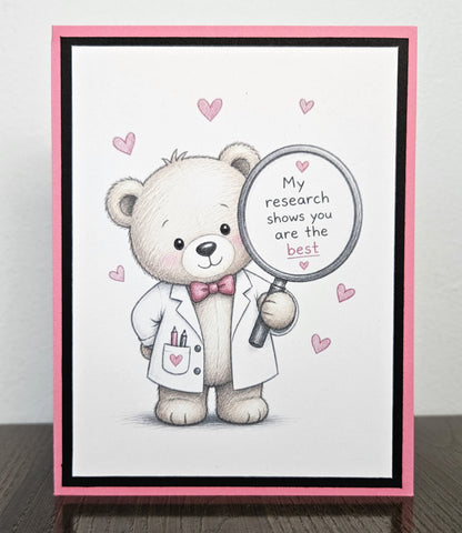 Standing front of a handmade appreciation card with a scientist teddy bear holding a magnifying glass reading My research shows you are the best, framed in pink and black.