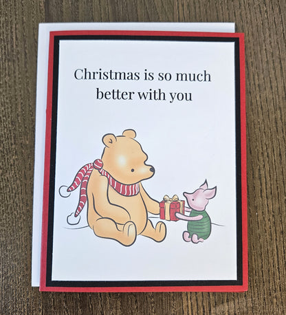 Winnie the Pooh and Piglet Christmas friendship card with a white envelope on a wooden surface.