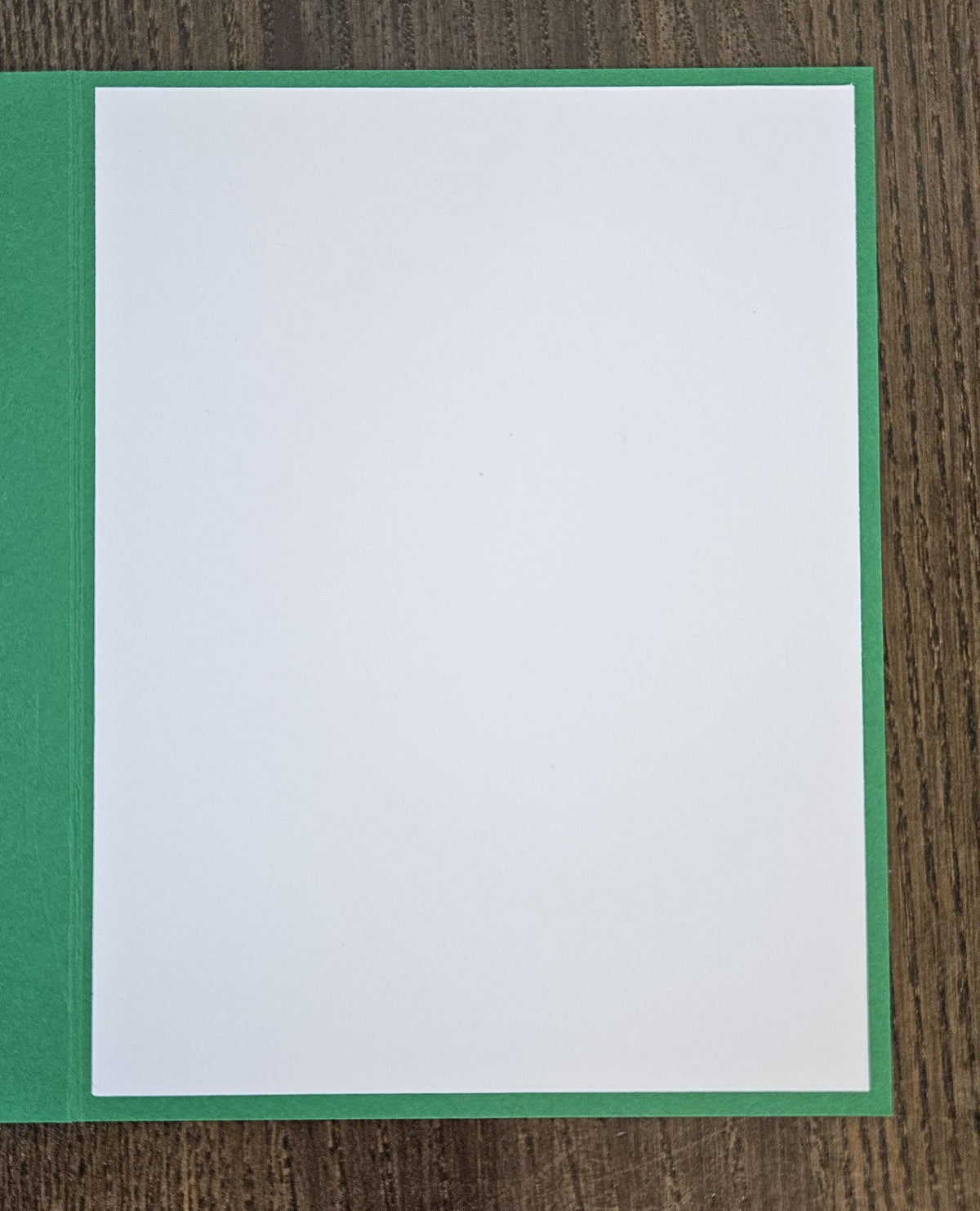 Open green holiday card showing a blank white interior writing panel.